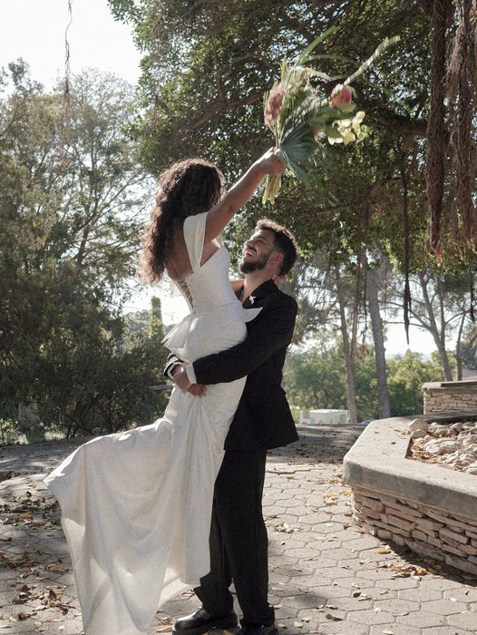 החתן מרים את הכלה בצילומי חוץ